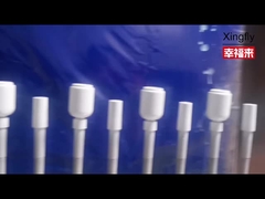 Lavoro quotidiano in fabbrica: verniciatura a spruzzo di bottiglie di vetro